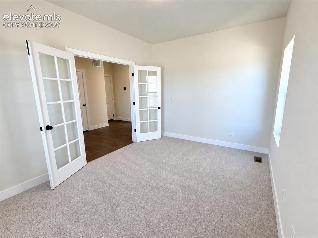 Image 3 of 26: Plush carpet flooring, white trim, and a window