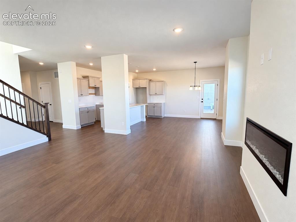 Image 5 of 26: Wood-finish flooring, built-in electric fireplace, contemporary kitchen cab