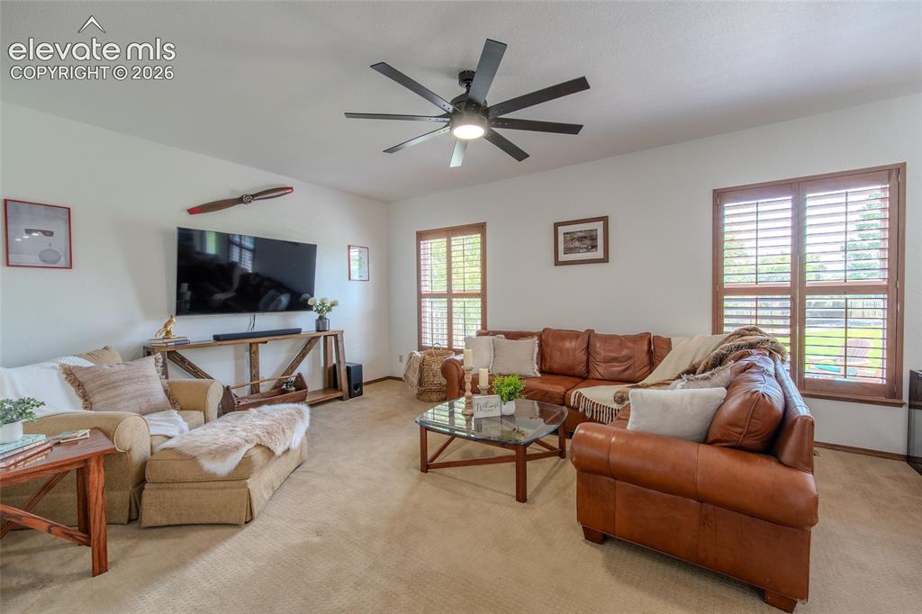 Image 18 of 44: Main floor family room with plantation shutters, access to half bath and l