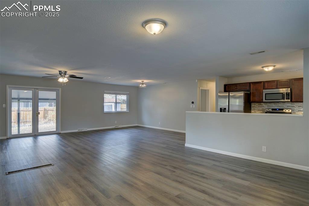 Image 14 of 43: Unfurnished living room featuring wood-style flooring and a ceiling fan