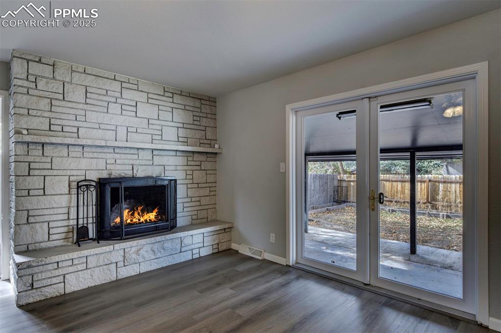 Image 15 of 43: Unfurnished living room featuring wood type floors, walkout to backyard and