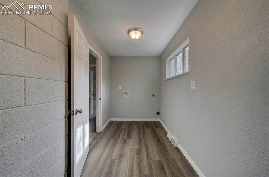 Image 16 of 43: Laundry room featuring wood-type flooring, hookup for a washing machine, an