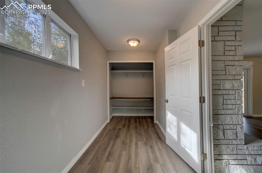 Image 17 of 43: Laundy room with baseboards and wood-style flooring, and a closet