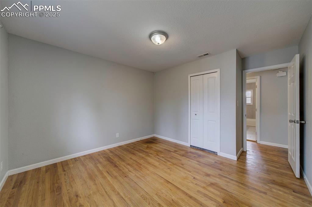 Image 21 of 43: Unfurnished bedroom featuring wood floors and a closet