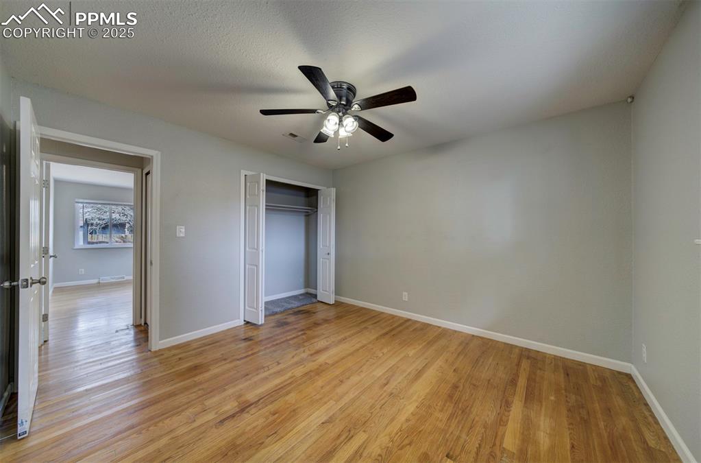 Image 23 of 43: Unfurnished bedroom featuring wood floors, ceiling fan and a closet