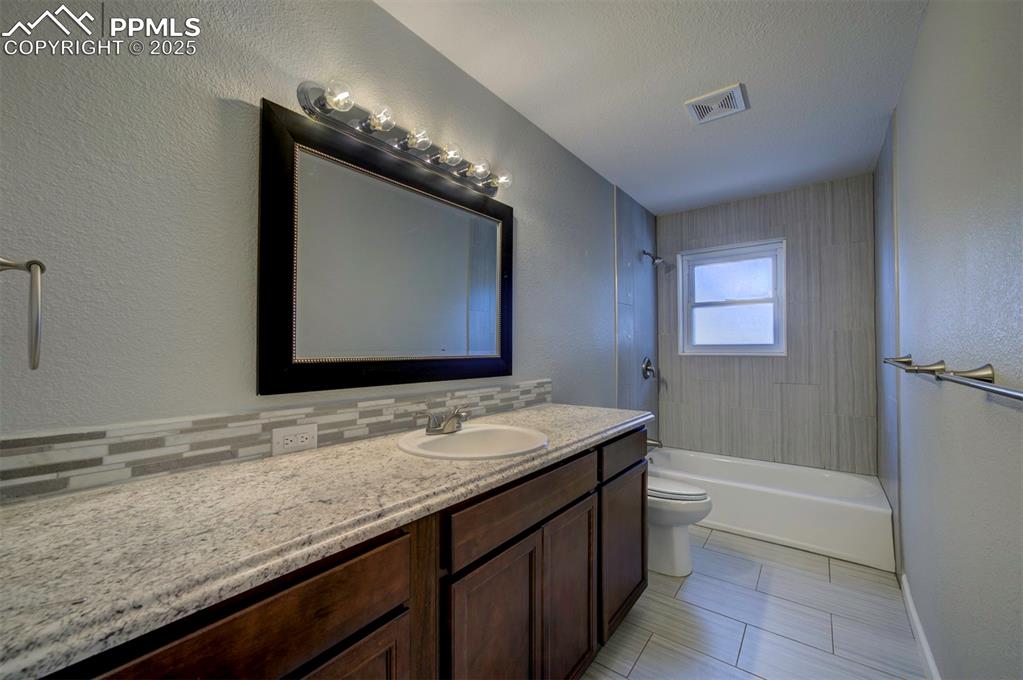Image 27 of 43: Full bathroom with  vanity, tiled shower / tub combination, tasteful backsp