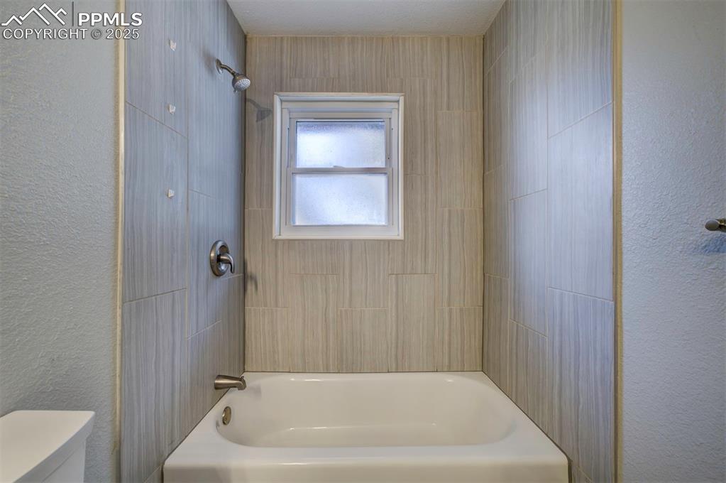 Image 28 of 43: Bathroom featuring a tiled shower / tub combination