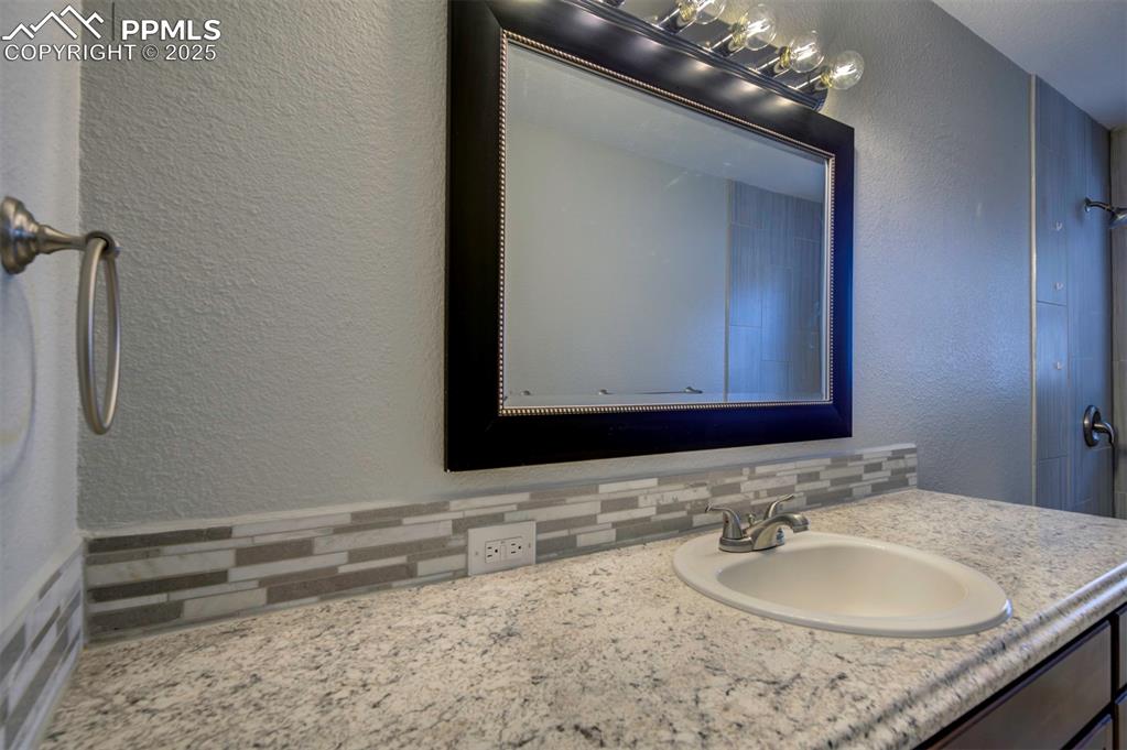 Image 29 of 43: Bathroom featuring a tasteful backsplash, and vanity