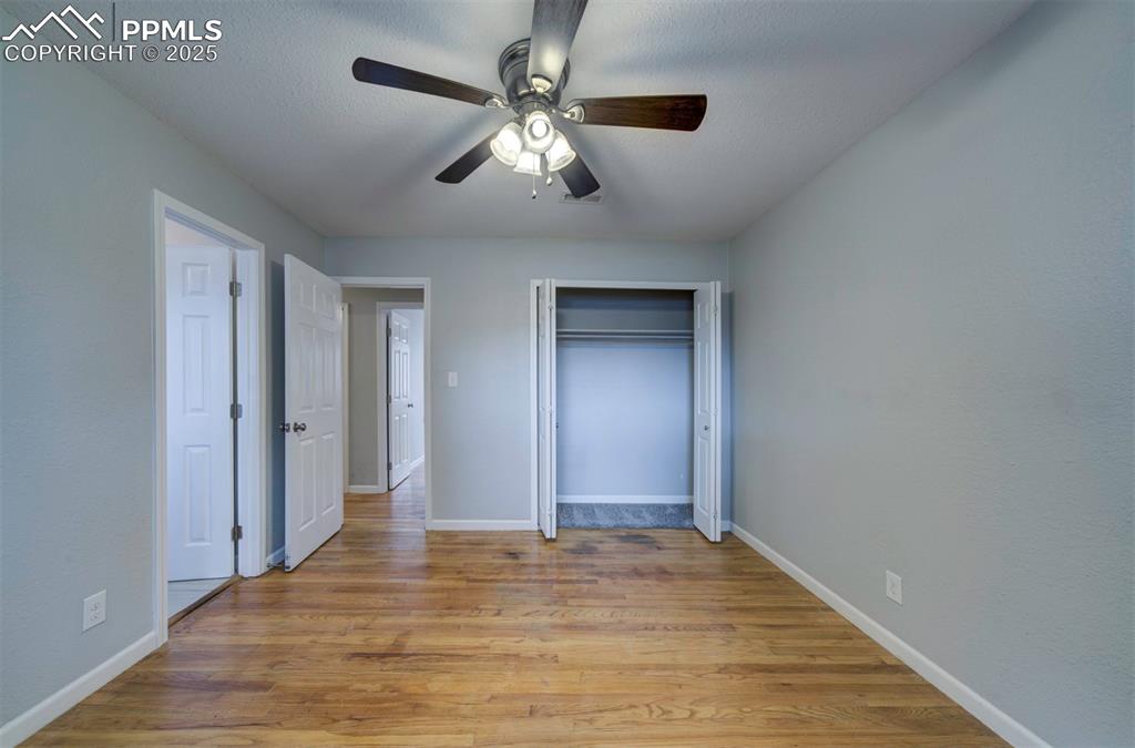 Image 30 of 43: Unfurnished bedroom featuring wood floors, ceiling fan and a closet