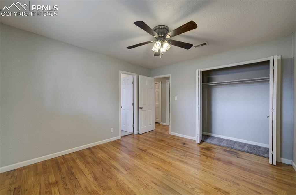 Image 31 of 43: Unfurnished bedroom featuring wood floors, ceiling fan and a closet