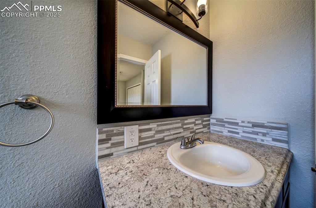 Image 35 of 43: Bathroom featuring vanity and decorative backsplash