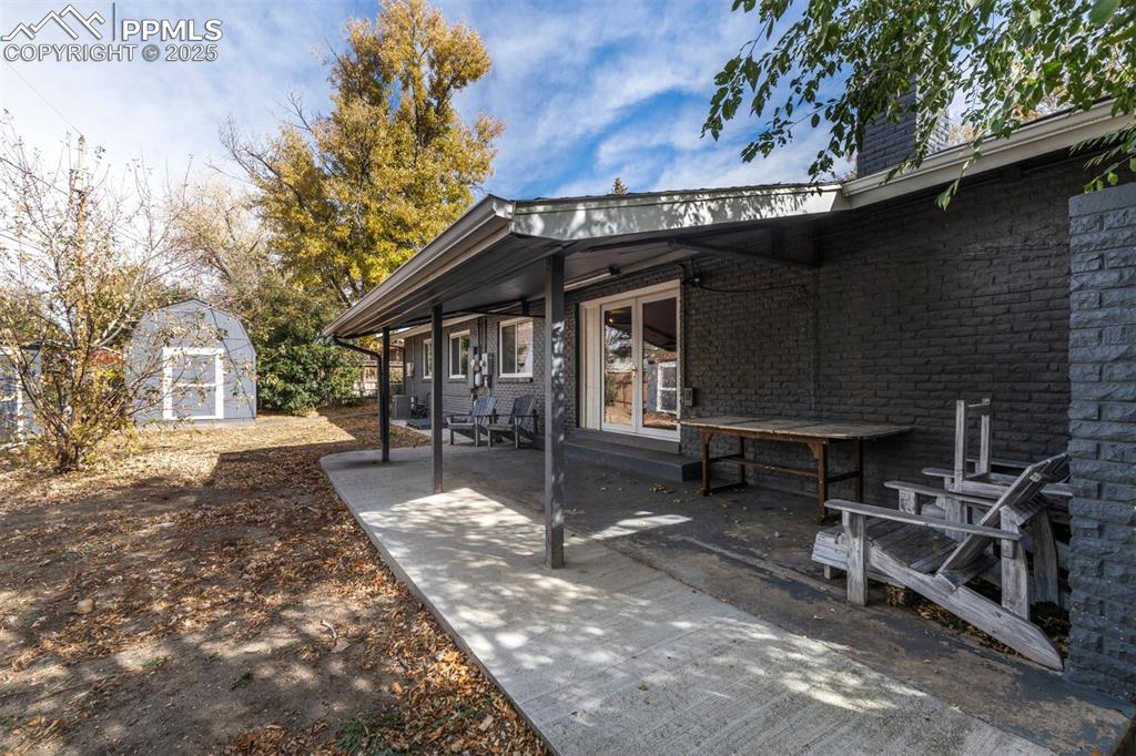 Image 38 of 43: View of covered patio featuring a 2 storage sheds