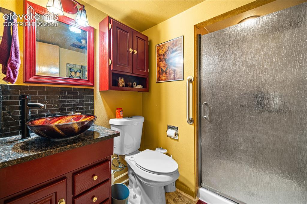Image 22 of 50: Carpeted room featuring a ceiling fan with light fixture, window with drape