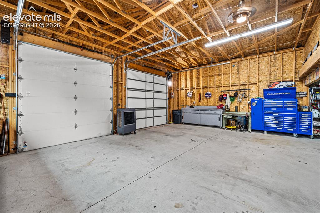Image 31 of 50: Living area featuring wood-finish flooring, two ceiling fans, and a built-i