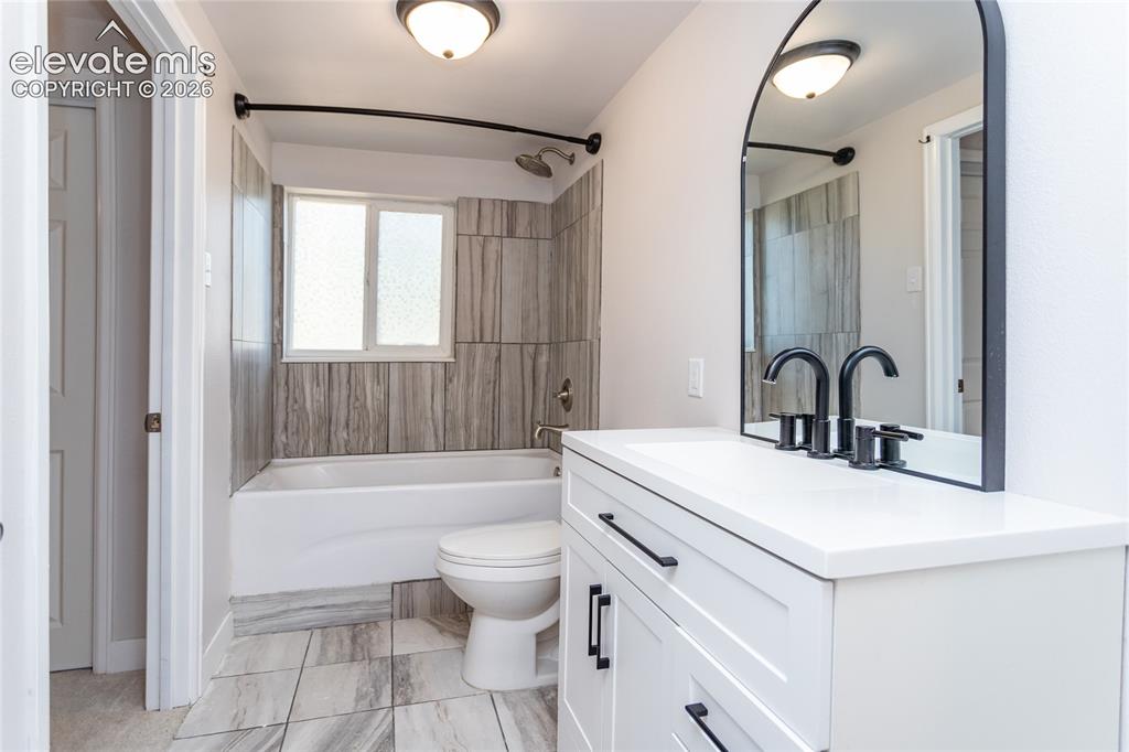 Image 16 of 25: Lower full bathroom that is open to hallway and 5th bedroom