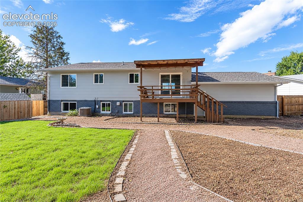 Image 18 of 25: Covered back deck overlooks expansive backyard.