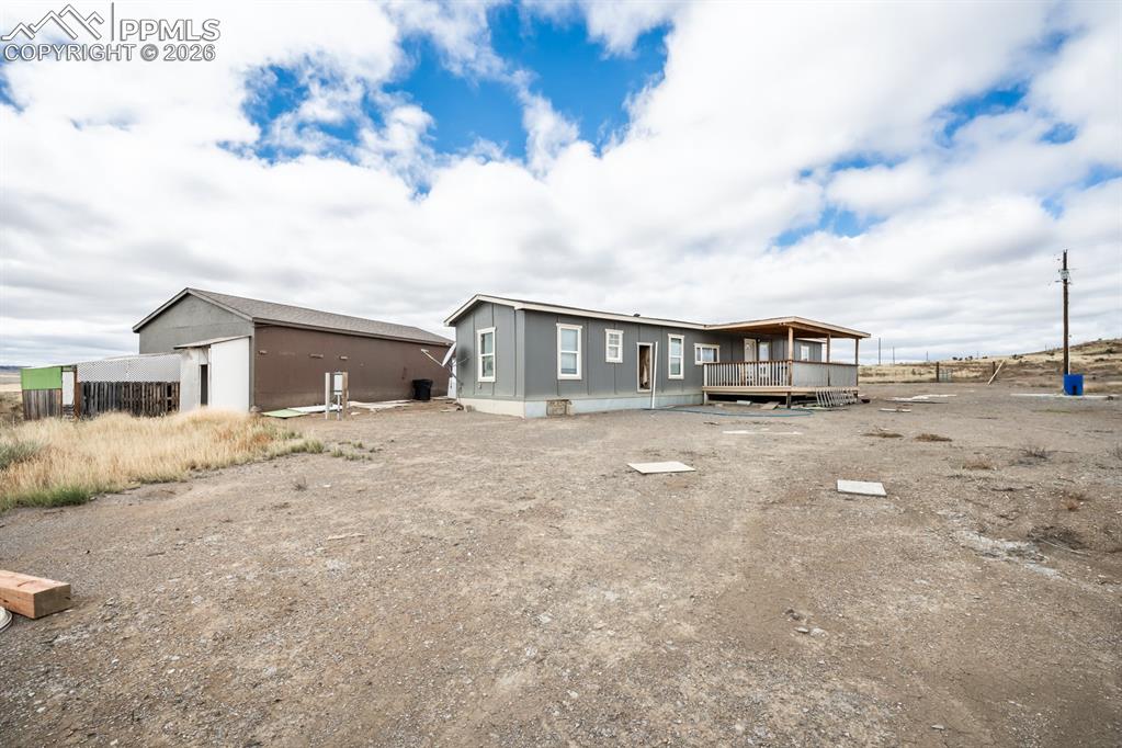 Image 10 of 13: Back of property featuring a deck and an outdoor structure