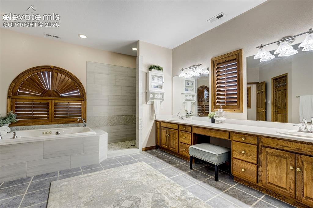 Image 20 of 49: Updated primary bathroom with spa shower and tub