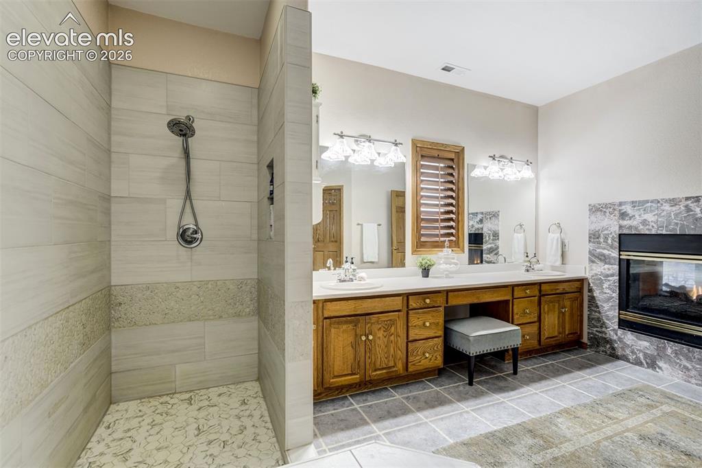 Image 21 of 49: 5 piece primary bathroom and spa inspired shower and fireplace