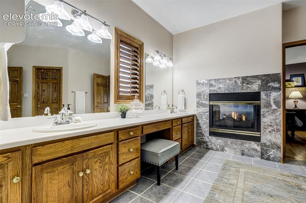 Image 23 of 49: Primary Bathroom with double sided vanity and double sided fireplace
