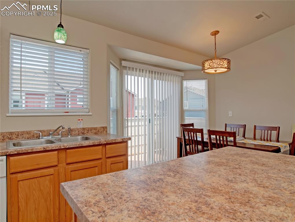 Image 11 of 24: Kitchen featuring light countertops and hanging light fixtures