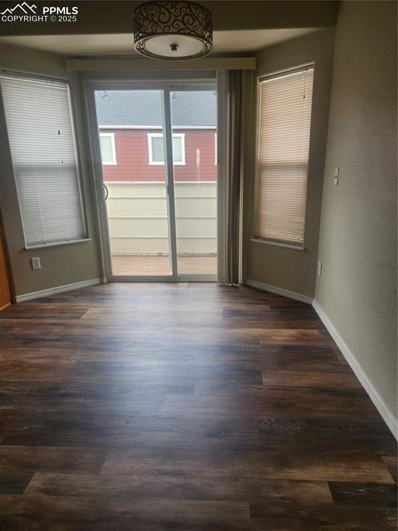 Image 14 of 24: Empty room featuring a textured wall and dark wood-type flooring