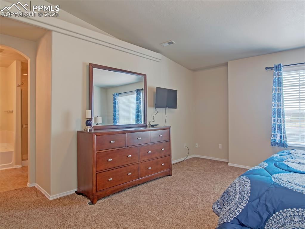 Image 15 of 24: Bedroom featuring light carpet and arched walkways