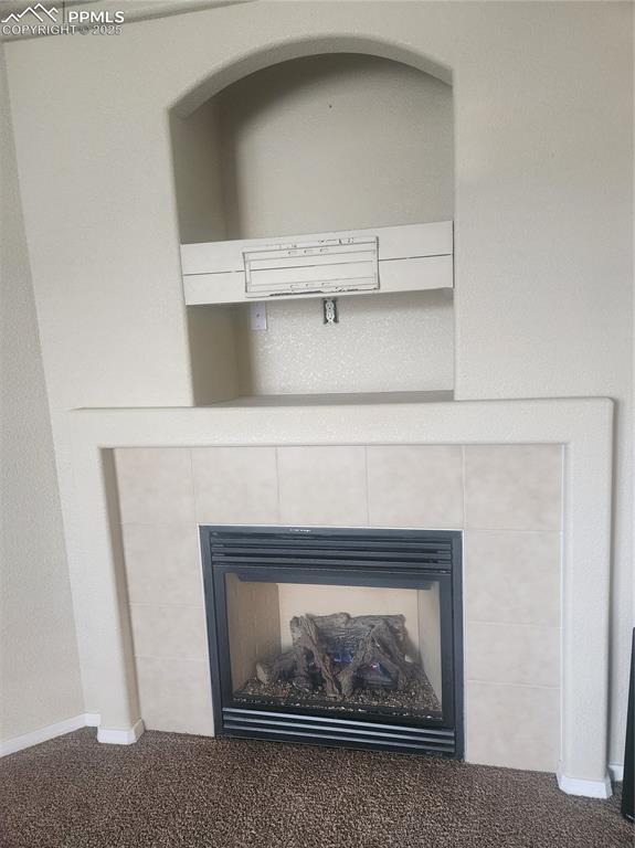 Image 6 of 24: Detailed view of carpet floors and a tile fireplace