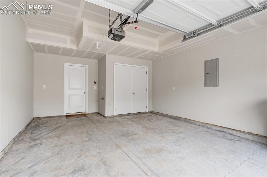 Image 15 of 26: The attached garage is finished on the interior and houses the utility clos