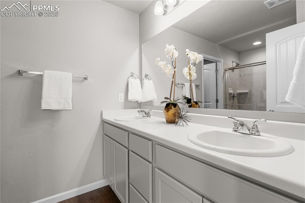 Image 20 of 26: The primary bathroom is stunning with solid surface countertops, a free sta