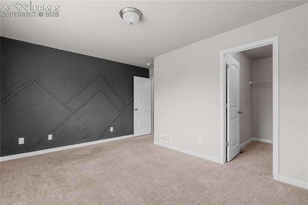 Image 22 of 26: The secondary bedroom has a beautiful accent wall and could be used as just