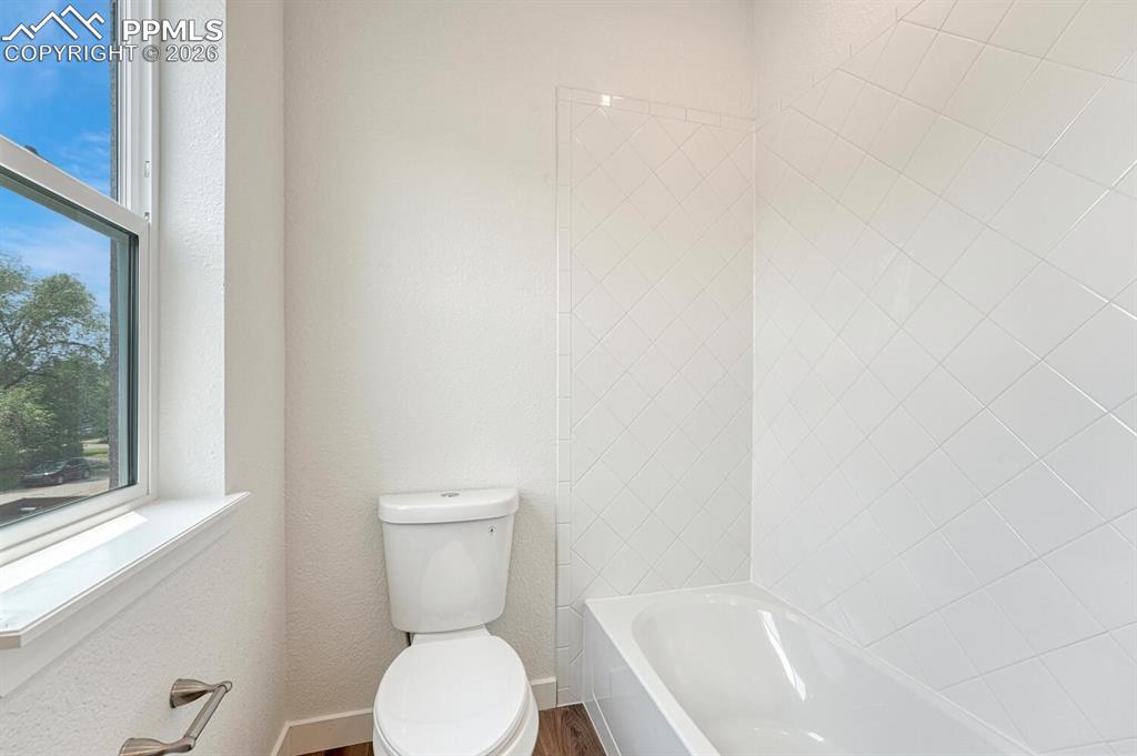 Image 15 of 34: Custom tiled shower tub in the primary bathroom.