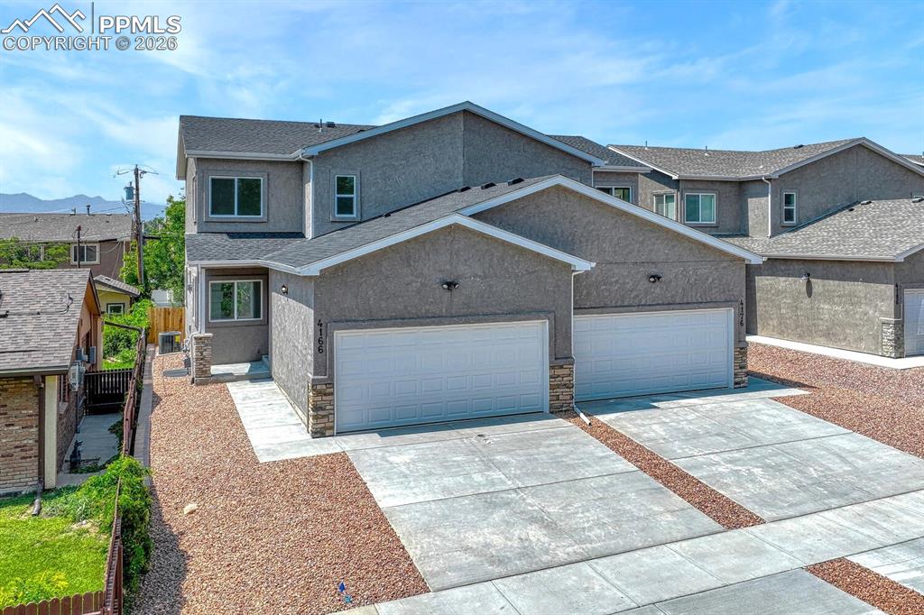 Image 2 of 34: Desirable stucco exterior and low maintenance xeriscaped front yard.