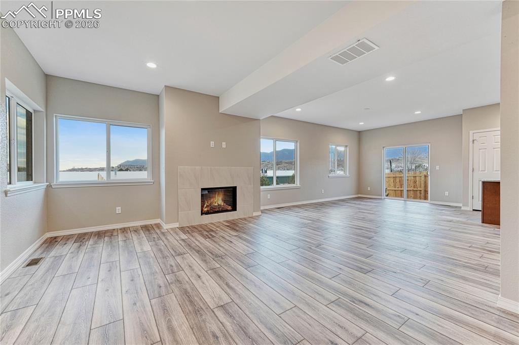 Image 5 of 34: Open living area with gas fireplace and tile surround designed by you!