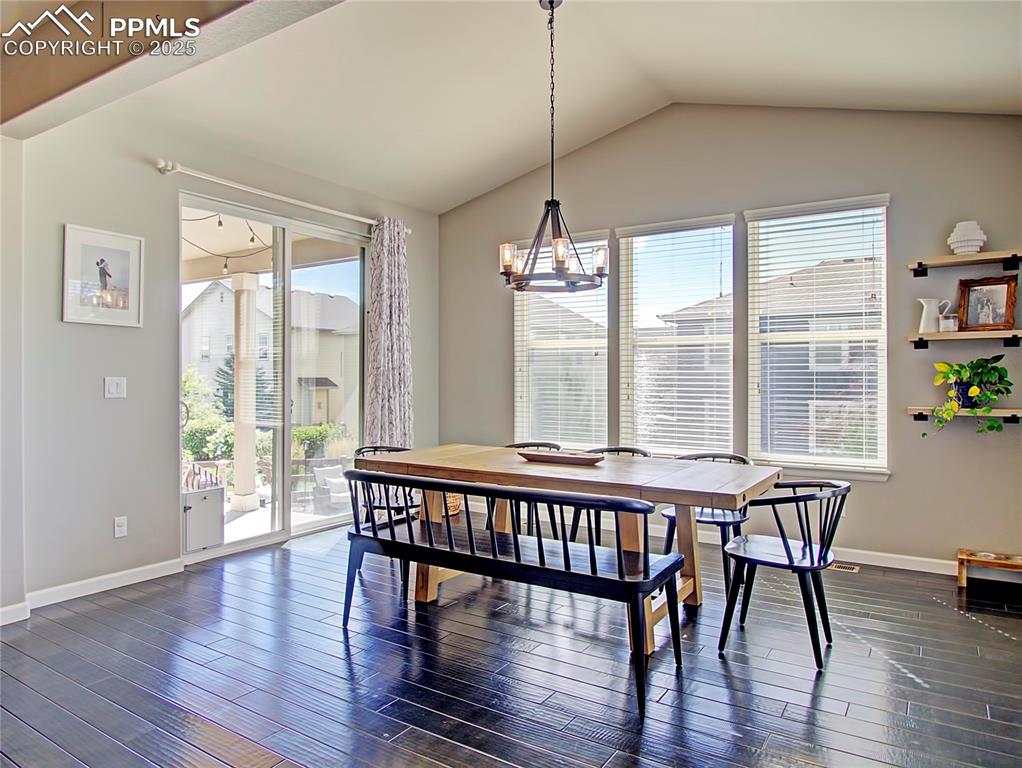 Image 17 of 44: Dining room with lofted ceiling, dark wood-style flooring, and a chandelier
