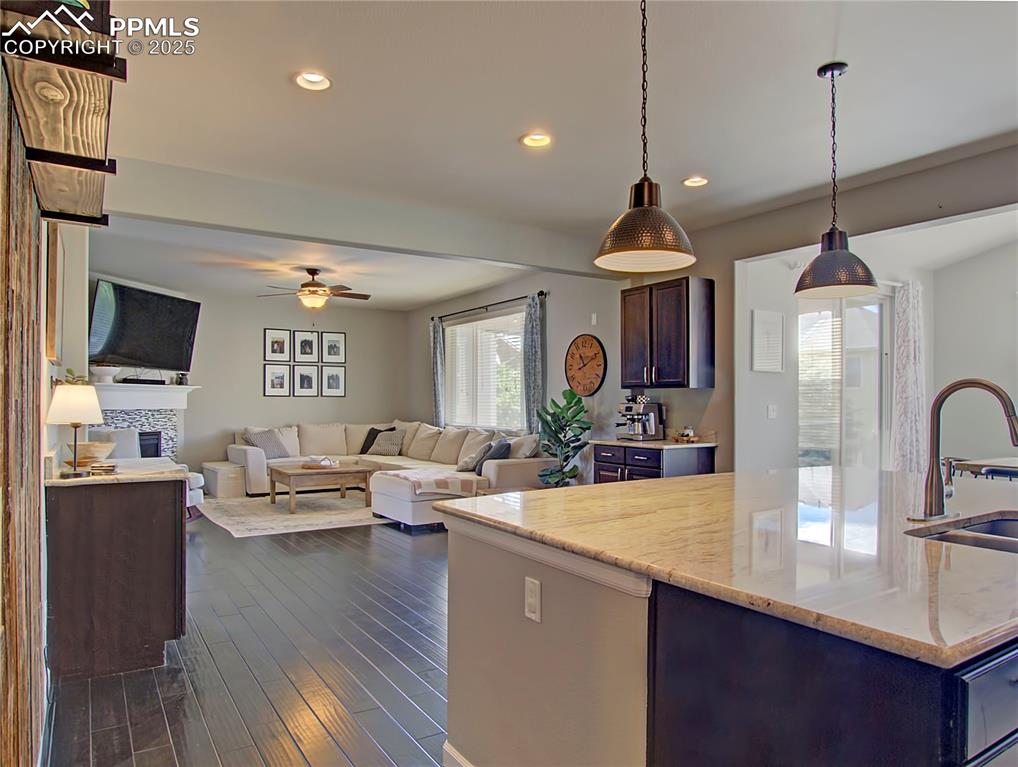 Image 18 of 44: Kitchen with pendant lighting, open floor plan, dark wood finished floors,