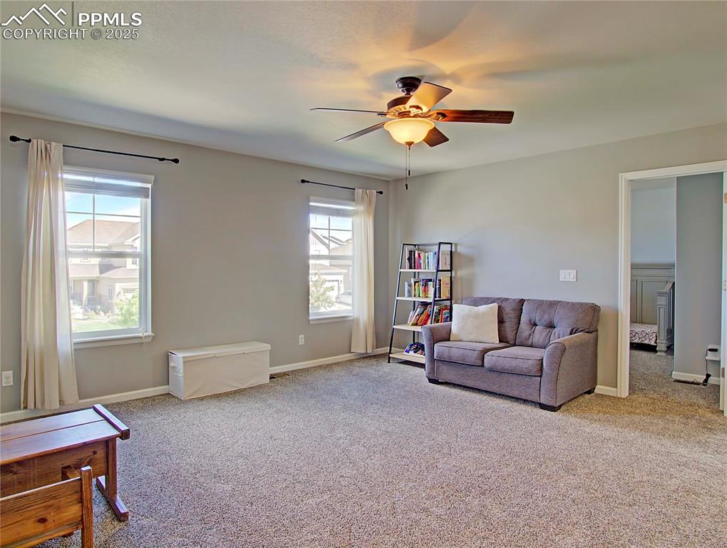 Image 20 of 44: Sitting room with light carpet and ceiling fan