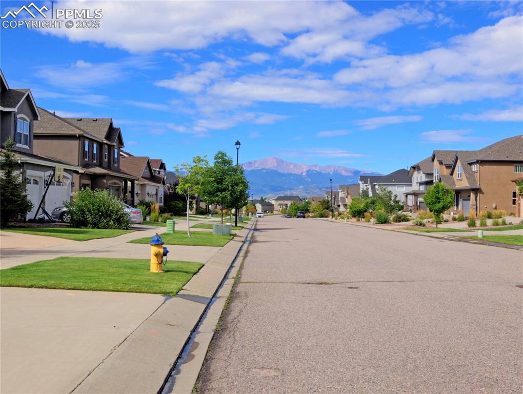 Image 39 of 44: View from street featuring Mountain views, street lighting, and sidewalks