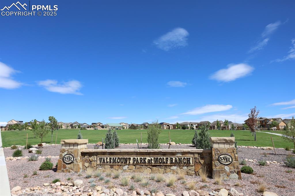 Image 40 of 44: Community sign featuring a yard and a residential view