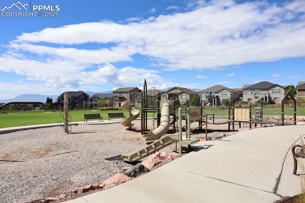 Image 42 of 44: Communal playground featuring a residential view and a lawn