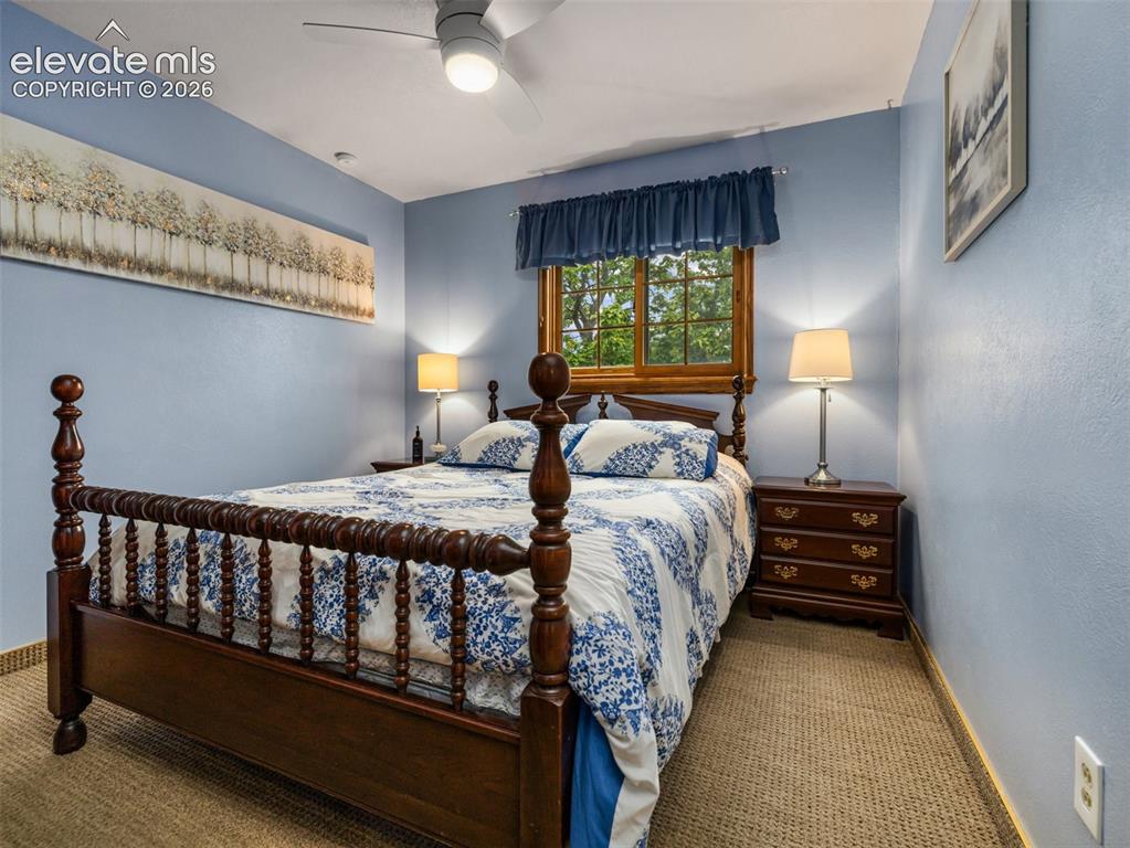 Image 13 of 34: Carpeted flooring with a wood window frame, a built-in ceiling fan with int