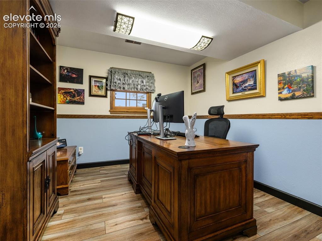 Image 21 of 34: Wood-finish flooring, built-in shelving, two-tone wall treatment, and a win