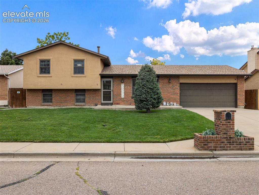 Image 34 of 34: Brick and stucco exterior, attached garage, well-maintained lawn, paved dri