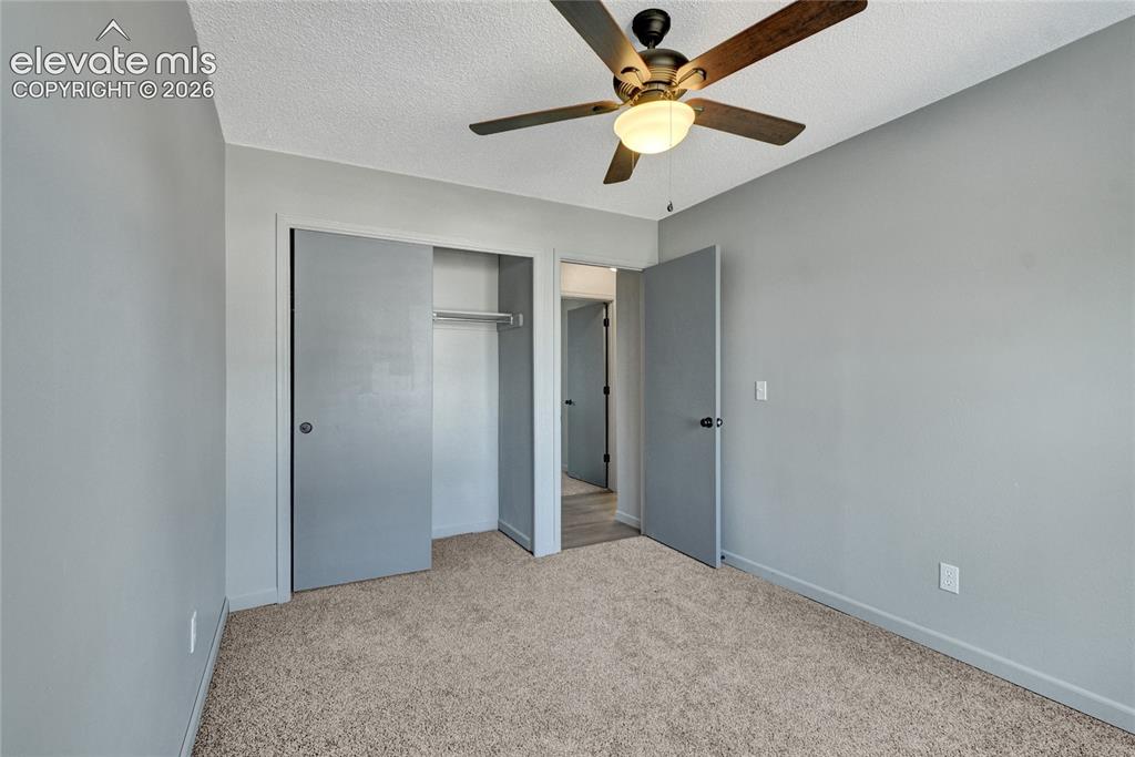 Image 17 of 23: Carpeted room with light gray walls, a ceiling fan with integrated lighting