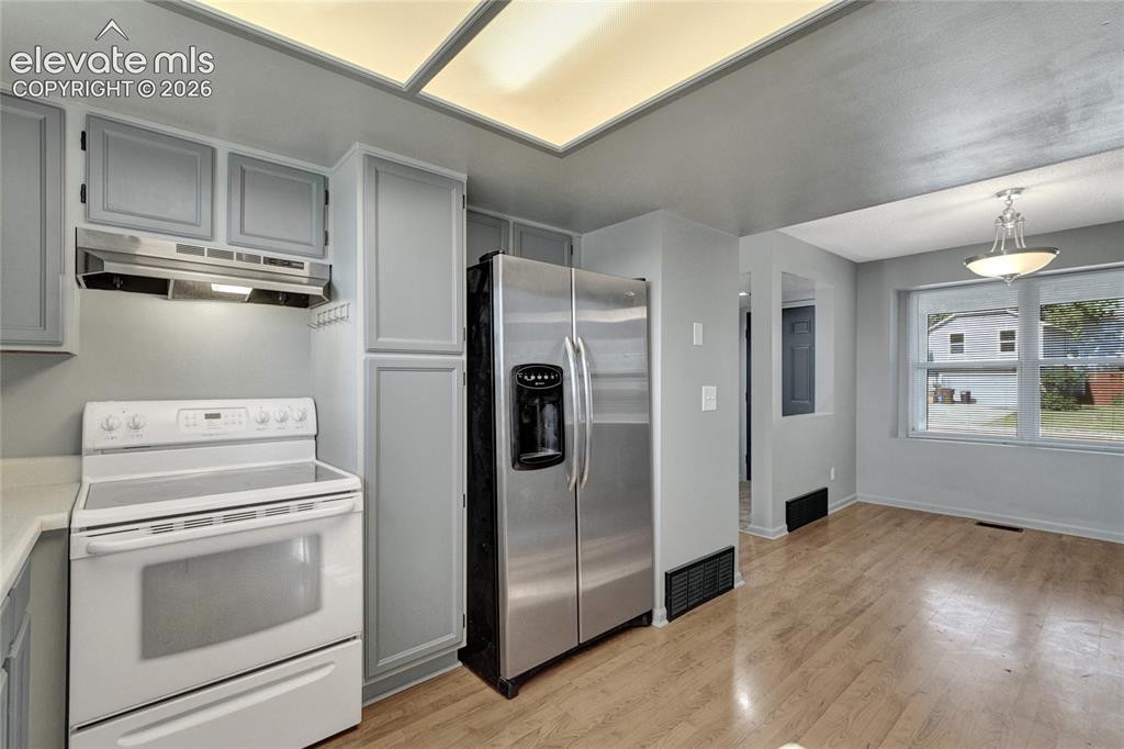 Image 8 of 23: Kitchen area featuring updated cabinetry, a stainless steel refrigerator, w