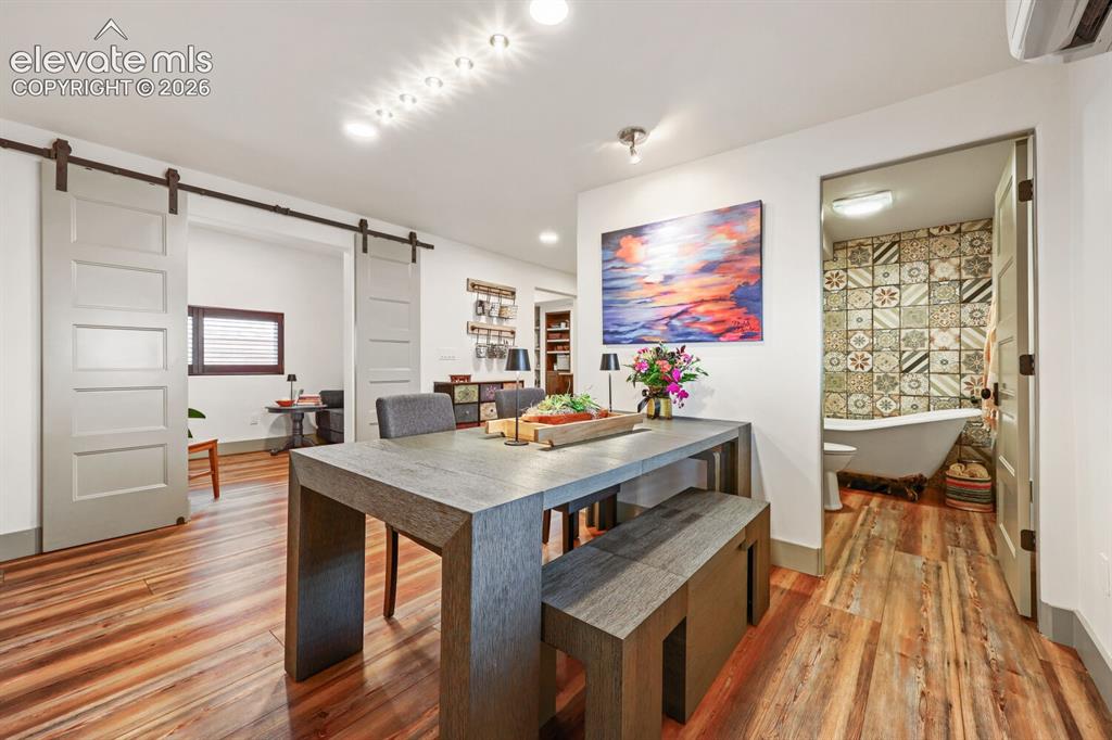 Image 11 of 30: Wood-finish flooring throughout, modern barn doors, recessed ceiling lighti