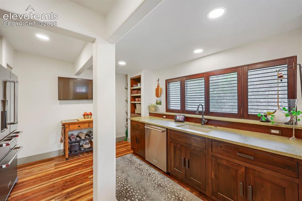 Image 13 of 30: Recessed lighting illuminates the kitchen, featuring stainless steel applia