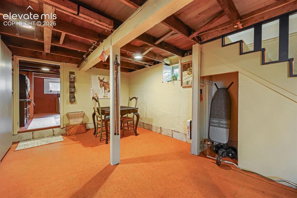 Image 23 of 30: Exposed wood beam ceiling with recessed lighting