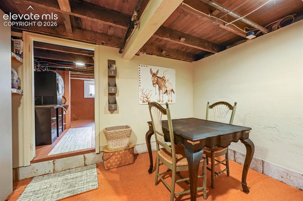 Image 24 of 30: Exposed wood beam ceiling, textured wall finish, and wood-finish flooring