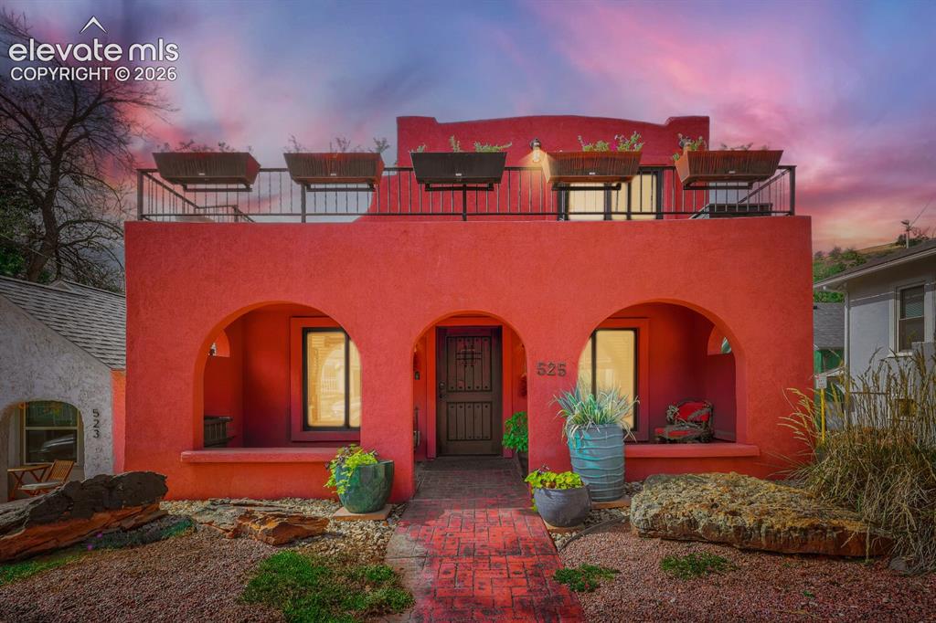 Image 3 of 30: Stucco exterior with arched entryways and a covered patio